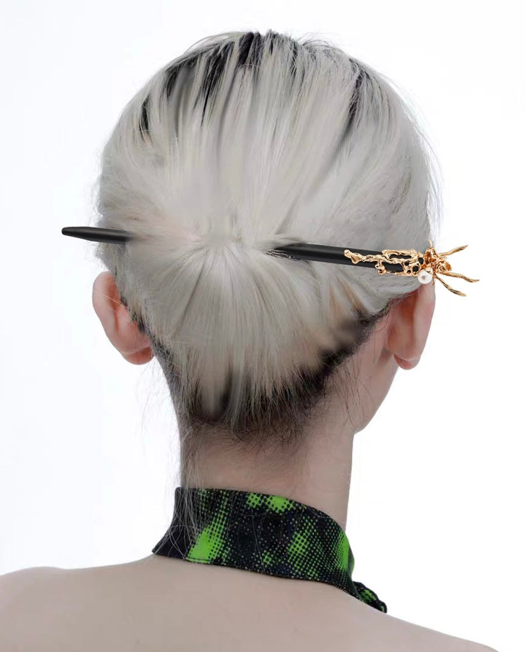 A person with short hair has their head turned to show the back where a black hair stick with gold dragon detailing is inserted. The stick is adorned with a pearl drop.