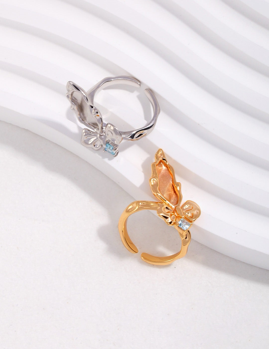Gold and silver butterfly earrings on a white background