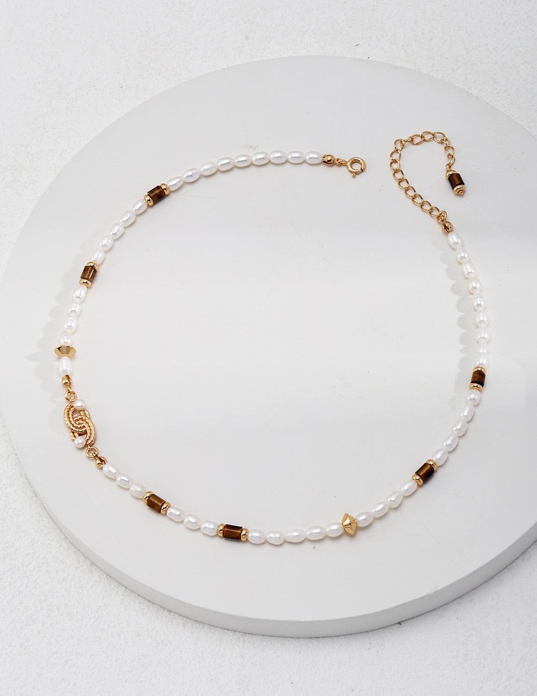 Front view of the tiger eye gemstone necklace display on a white circle surface