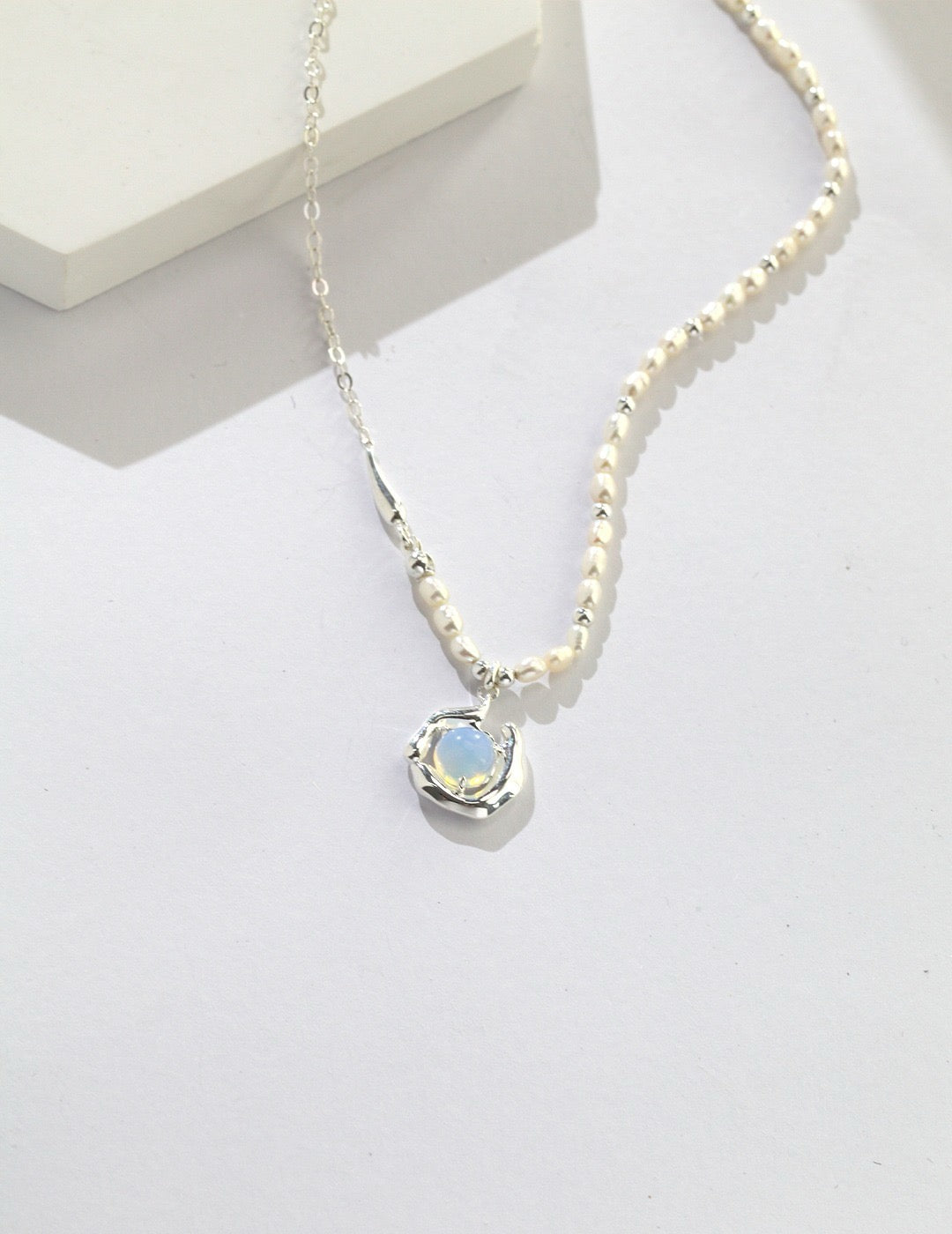 Celestia Drip Necklace in silver with pearl-detailed chain and glowing opalite pendant set in a fluid.
