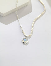 Celestia Drip Necklace in silver with pearl-detailed chain and glowing opalite pendant set in a fluid.