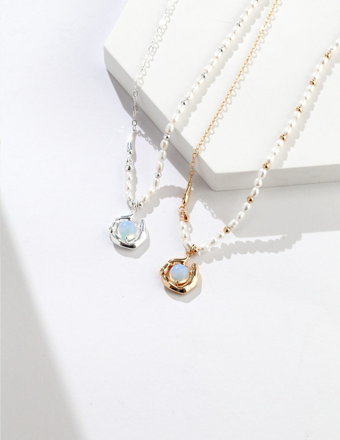 Celestia Drip Necklace in gold and silver with pearl-detailed chain and glowing opalite pendant set in a fluid, sculptural setting.
