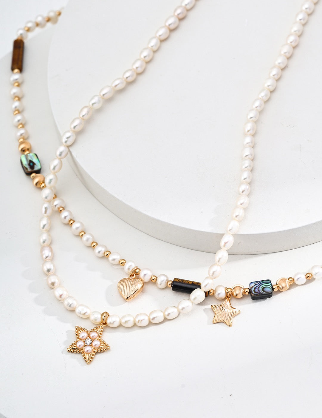 Pearl necklace with star-shaped charms on a white background