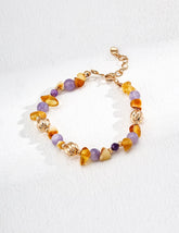 Multicolored gemstone beaded bracelet with gold accents on a white background