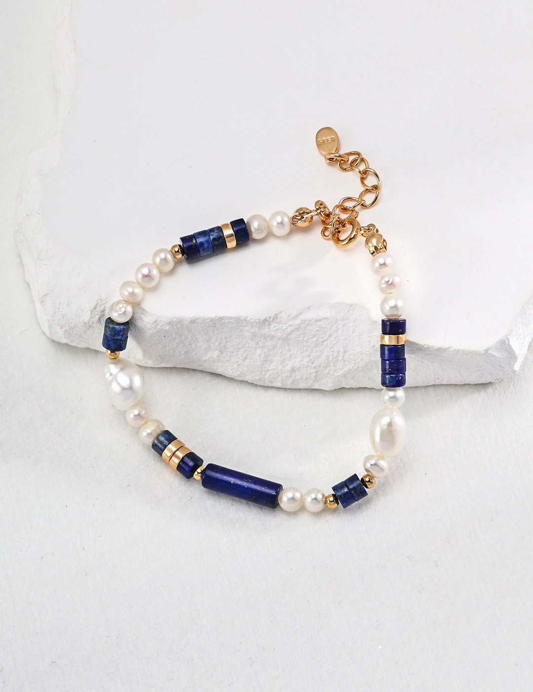 Bracelet with pearls and blue beads on a white background