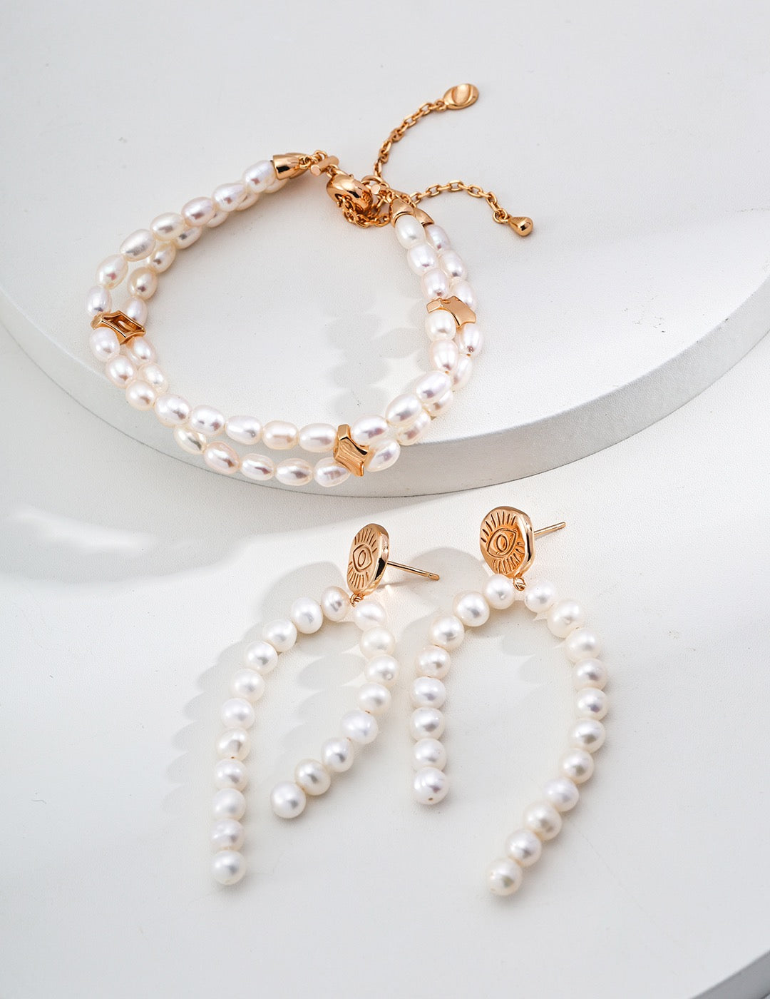 Pearl bracelet and earrings on a white background