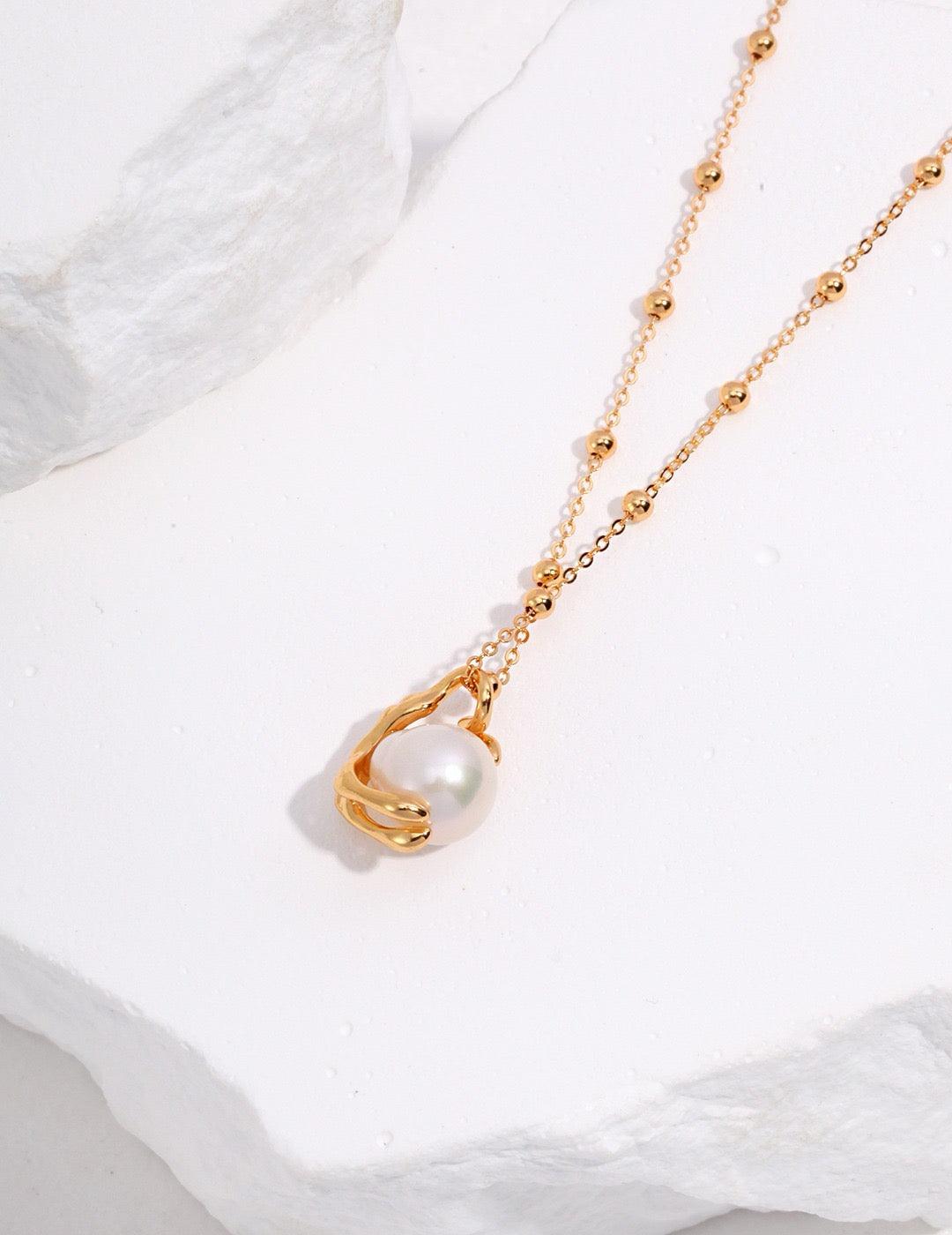 A baroque pearl pendant necklace with 18K Gold Vermeil on a white background.