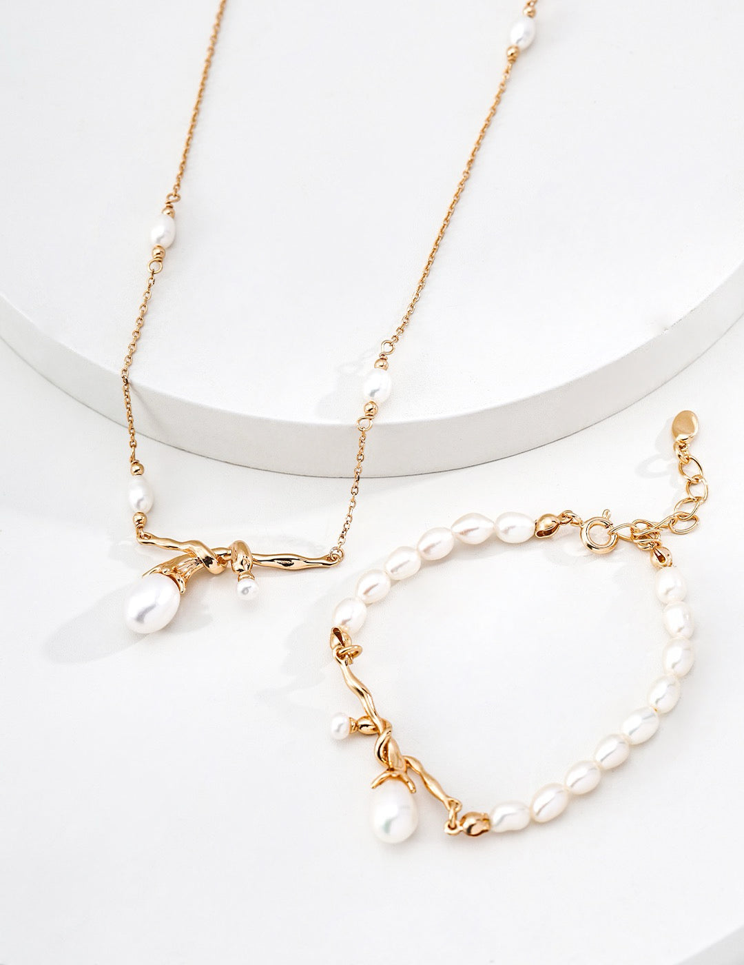 Close-up of Ethereal Knot pearl necklace and bracelet on a white display