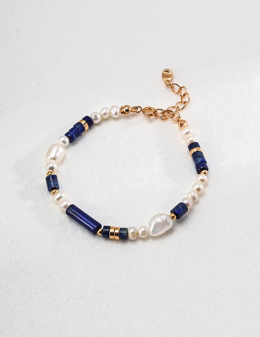 Bracelet with blue and gold beads on a light gray background