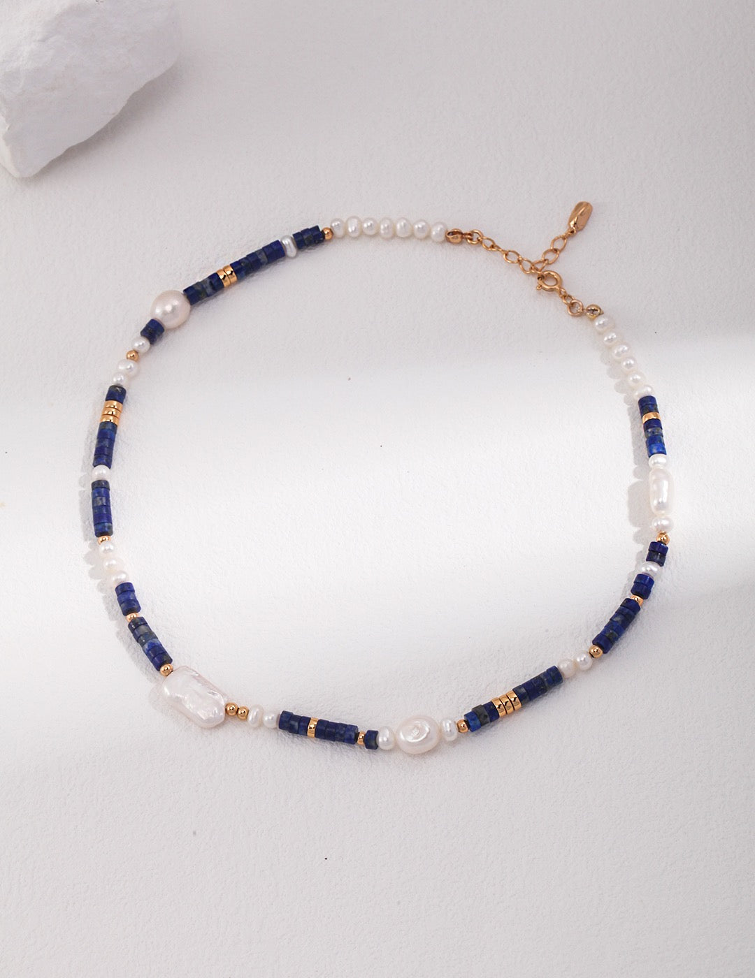 Necklace with blue and gold beads on a white background