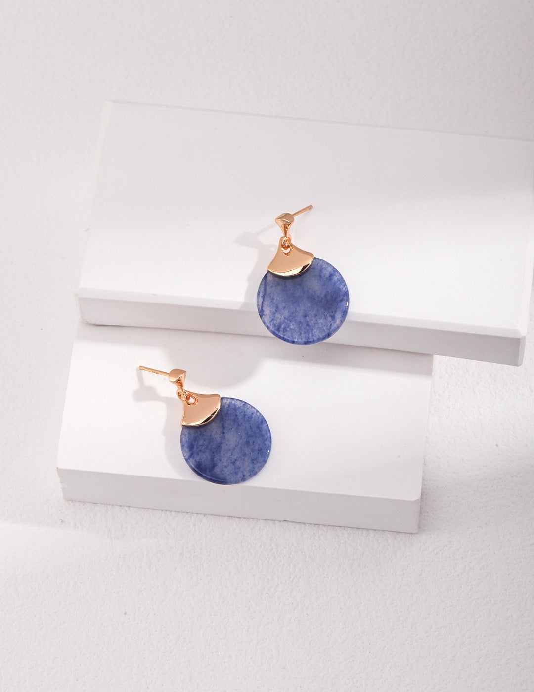 Pair of Blue Aventurine drop earrings with gold accents on a white surface