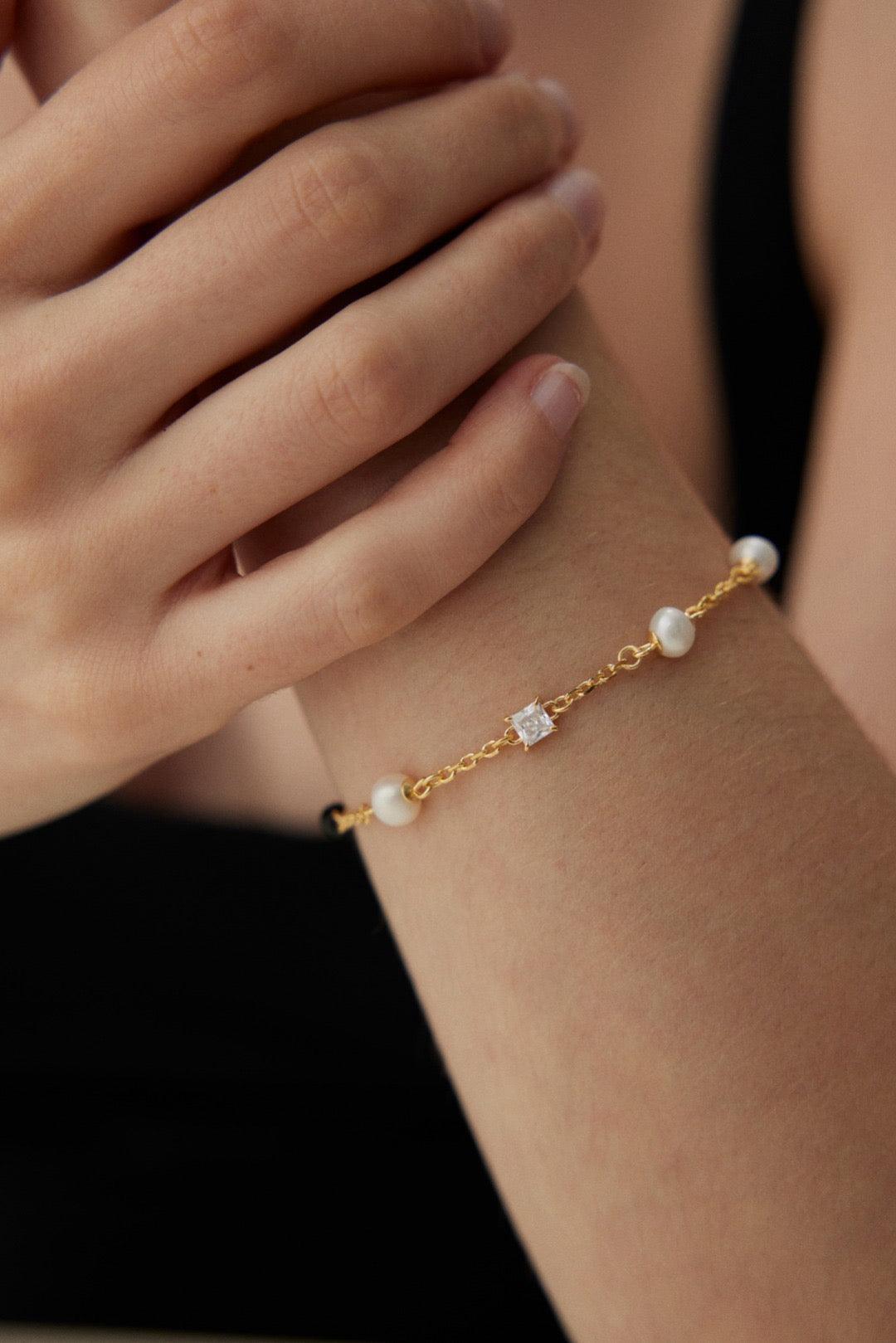 A close-up of Isla 18K Gold Freshwater Pearl Zircon Black Agate Bracelet on a model's wrist| Lia Atelier |Jewelry Sets