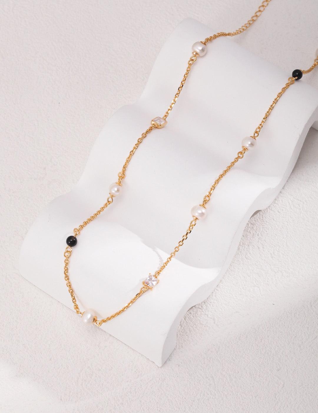 Isla Necklace, a beautiful piece featuring Freshwater Pearls, Zircon, 18k Gold Vermeil, and Black Agate.