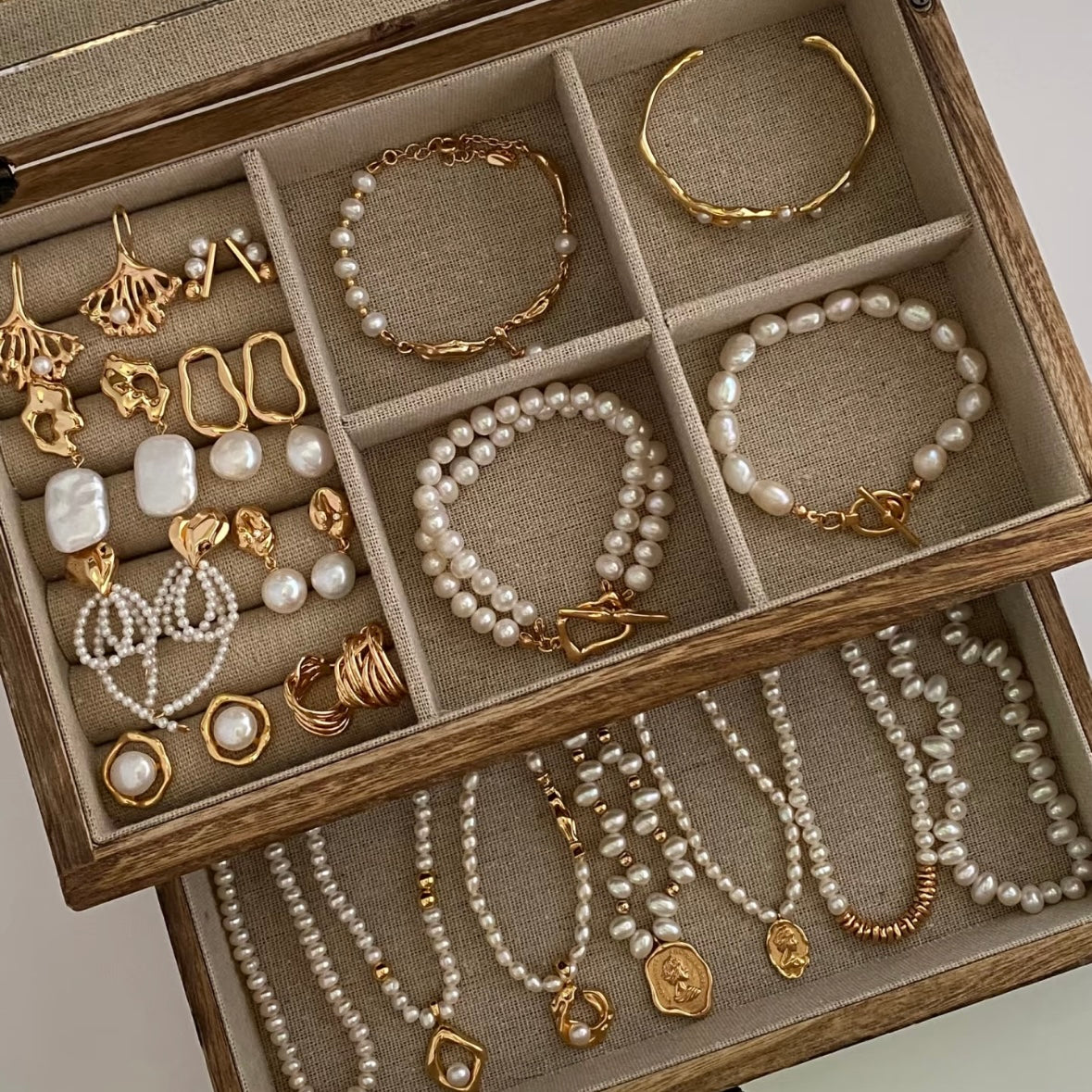 Jewelry set including necklaces, bracelets, and earrings displayed in a wooden box.