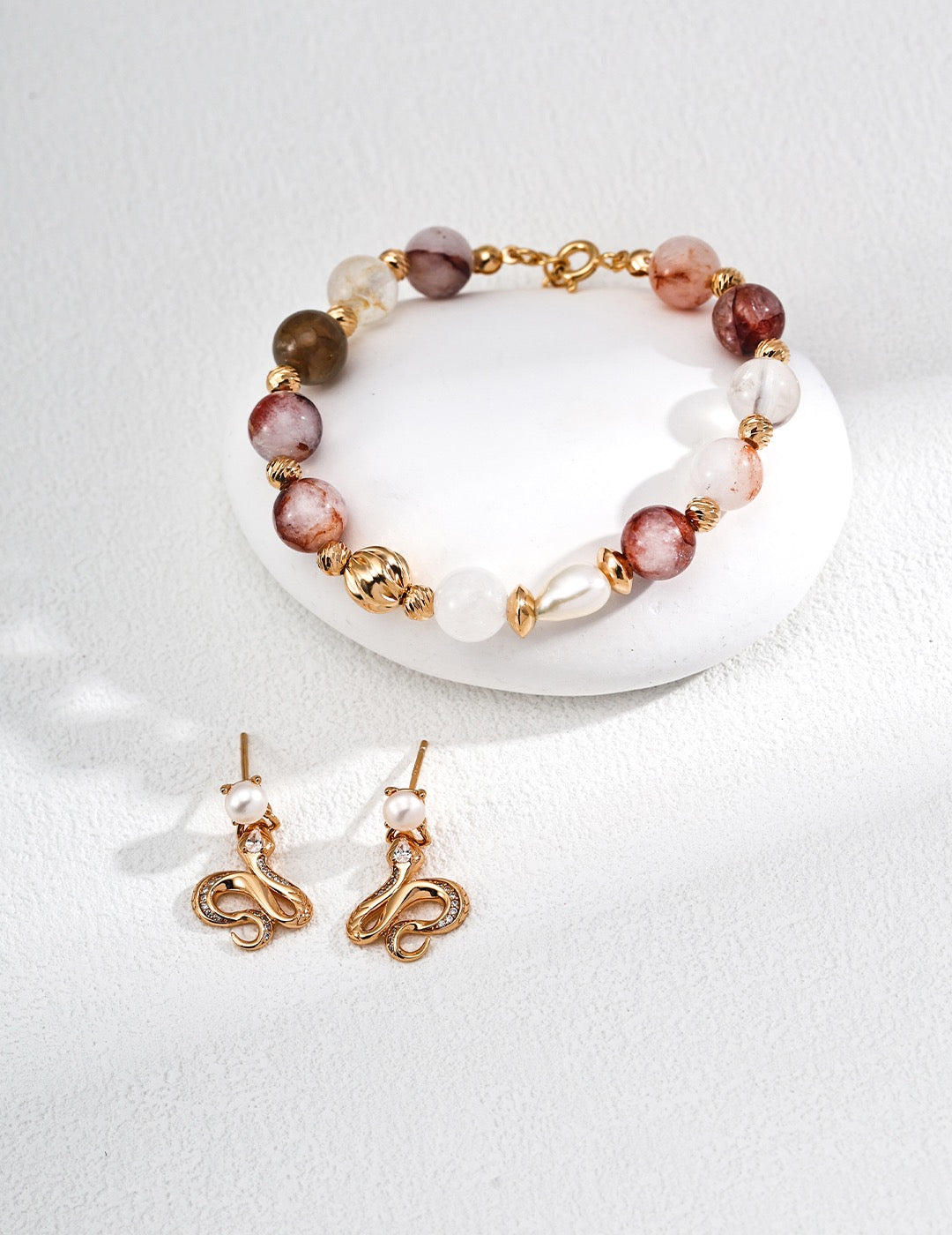 Gemstone Bracelet and earrings with gold accents and multicolored beads on a white background