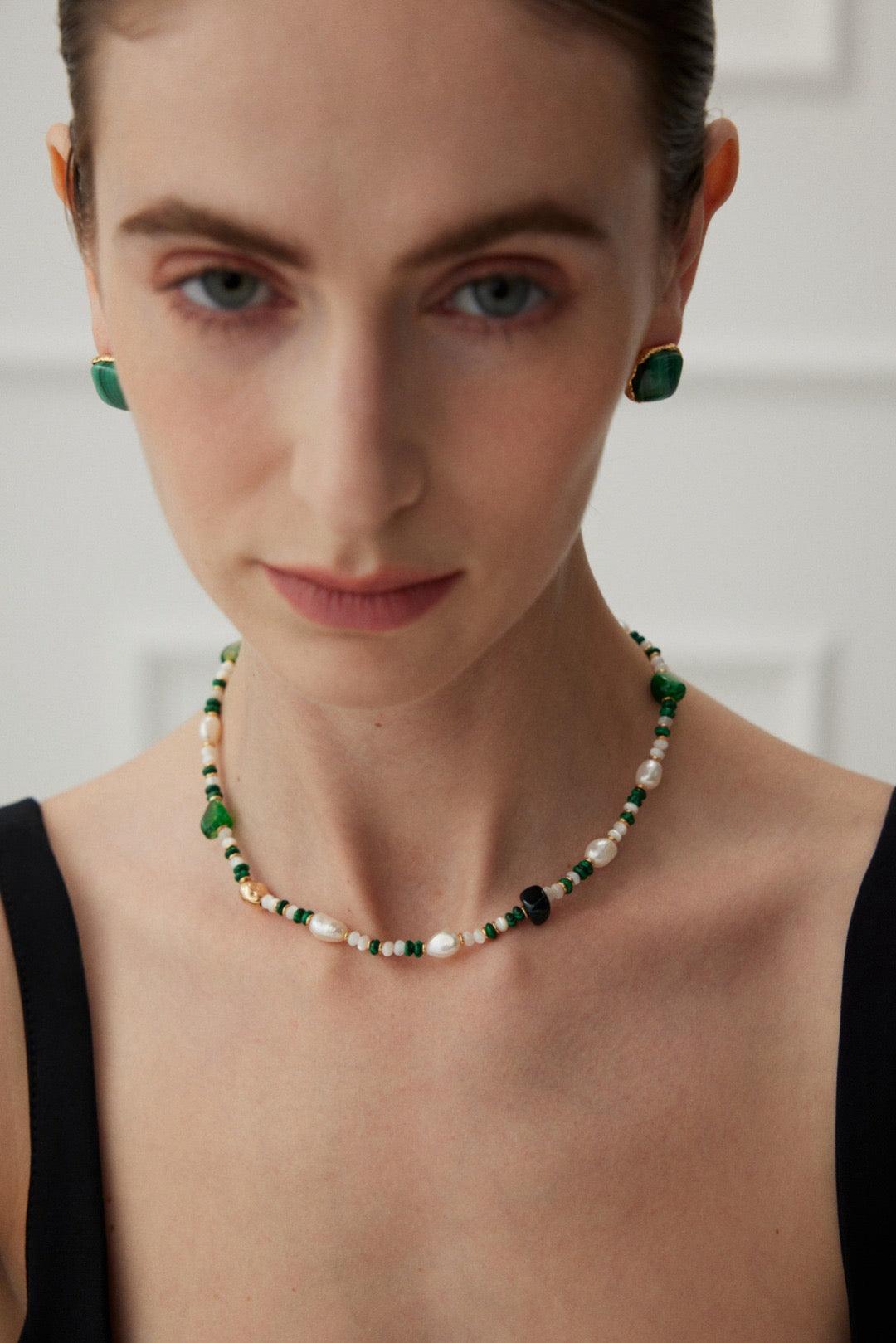 The model wears the Agate & Malachite gemstone Necklace with a black dress.