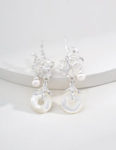 Sterling Silver dangle earrings with coral-like metal design, freshwater pearls, and circular mother-of-pearl pendants, styled on a white circle display.