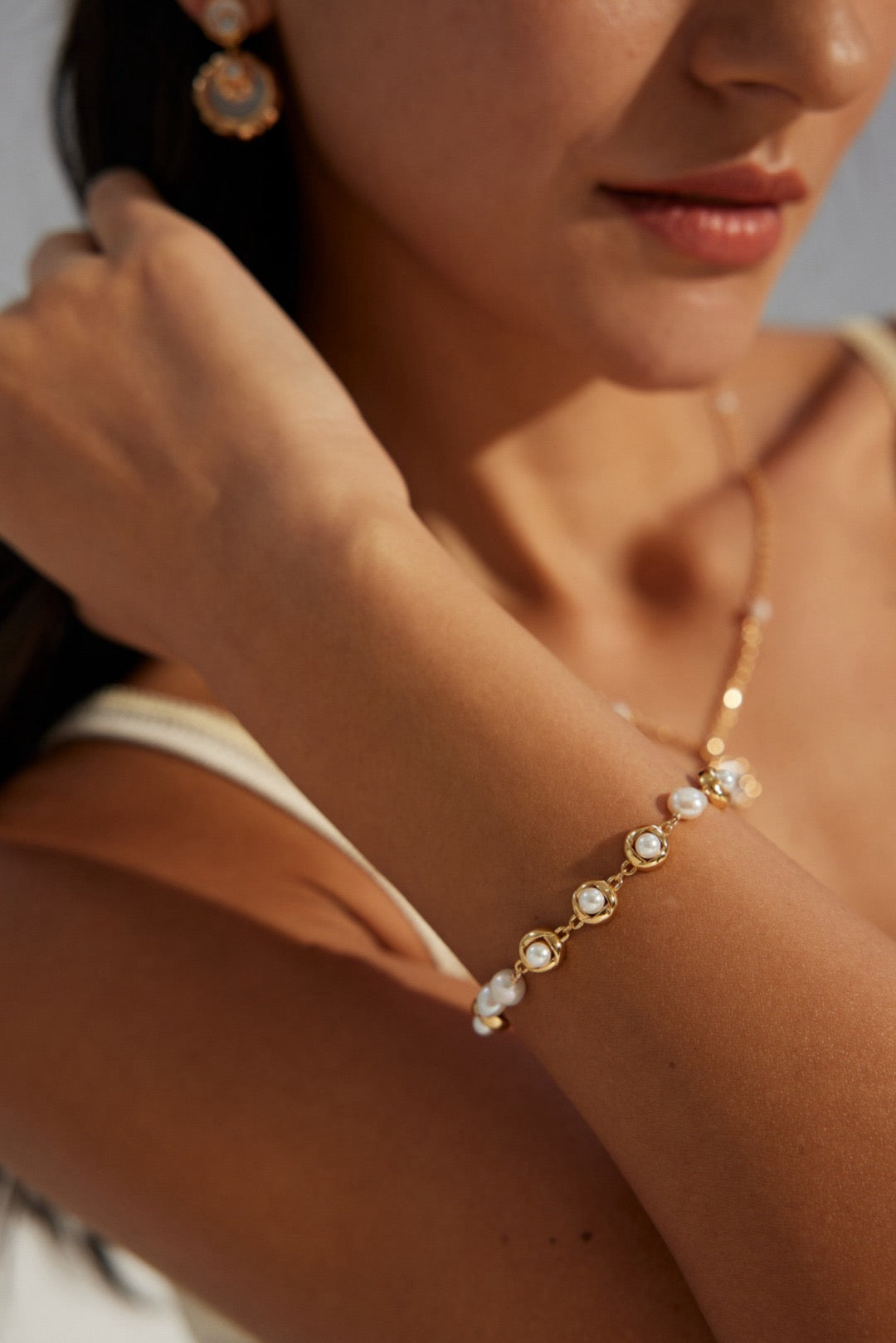 A lady is wearing the Orbit Pearl Link Bracelets in 18K Gold Vermeil
