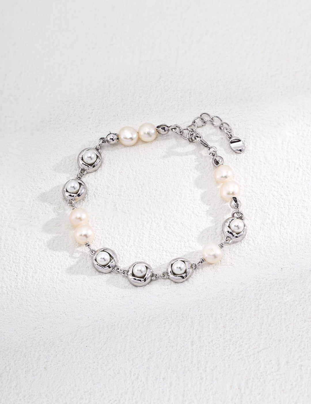 Orbit Pearl Link Bracelets in Sterling Silver display on the white background, showcasing the minimalist design.