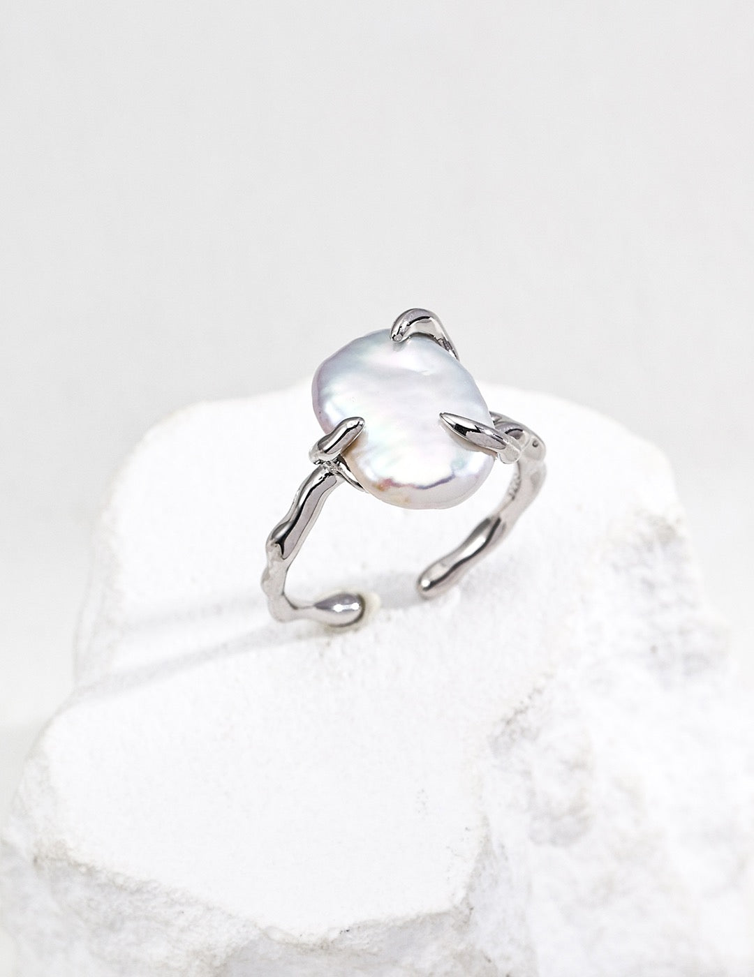 Sterling Silver baroque open ring with a central gemstone on a white background