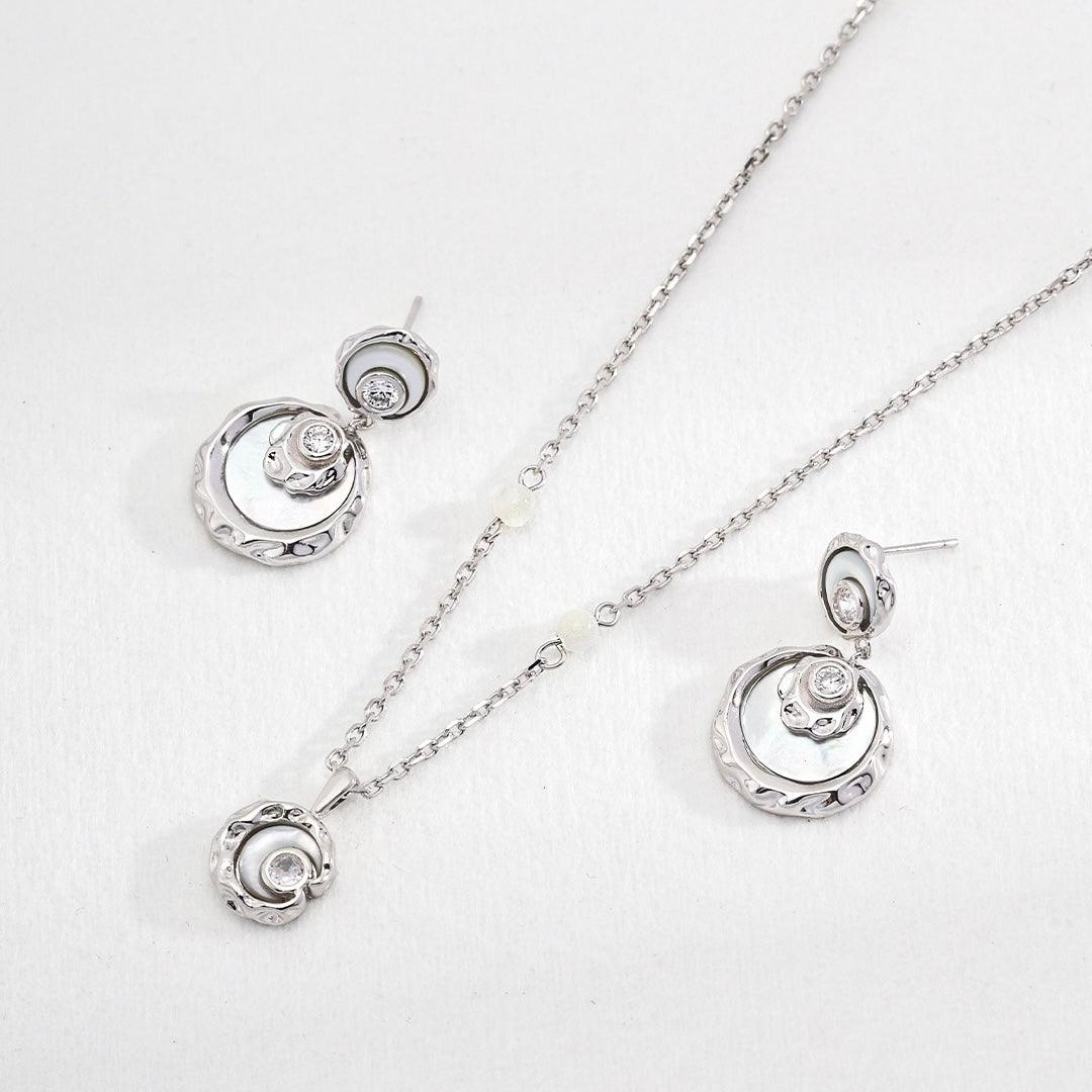 Sterling Silver Rayna Set necklace and earrings displayed on the white surface.