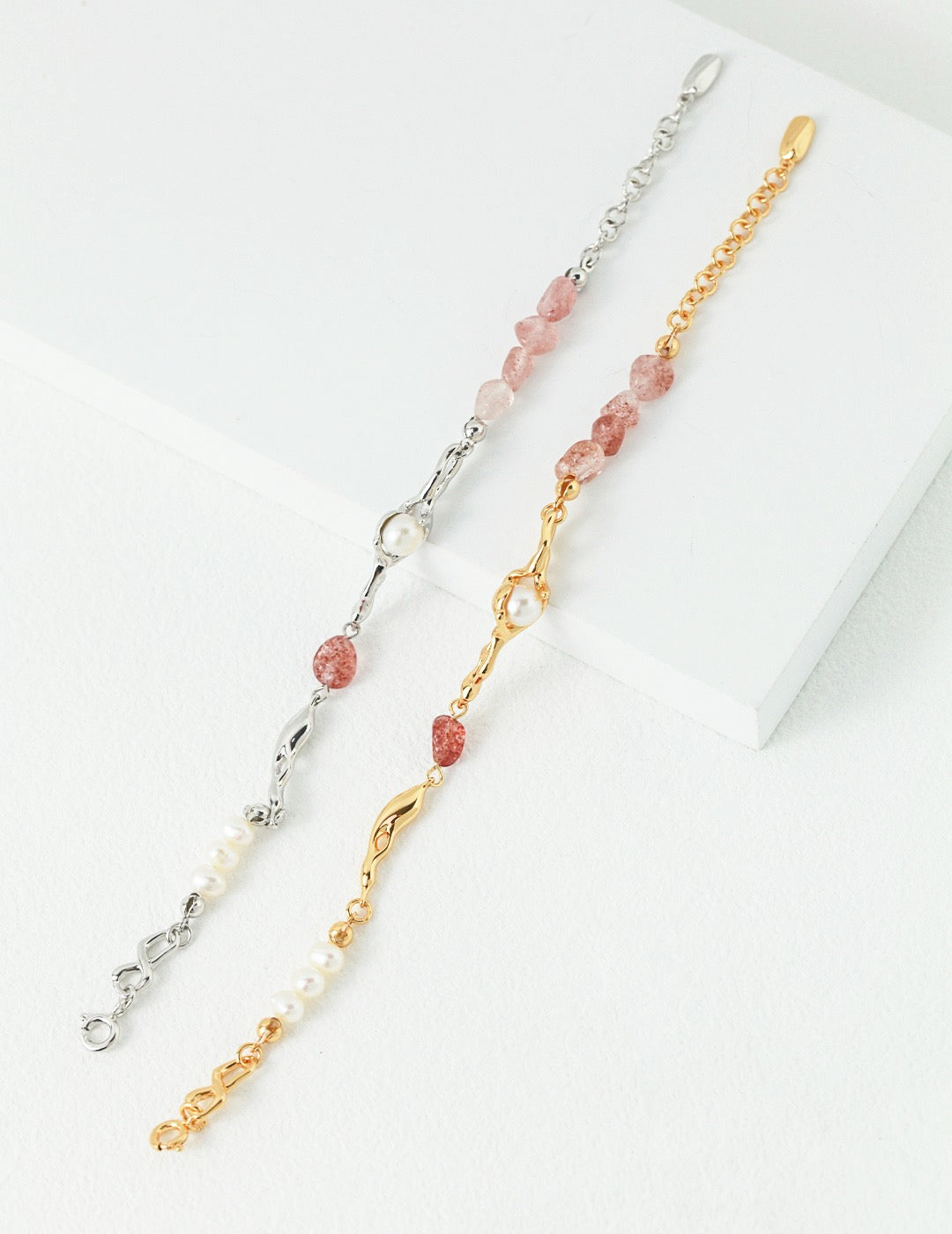 Two bracelets, one with 18K gold vermeil and the other in sterling silver, both featuring asymmetrical rows of pearls and raw strawberry quartz.