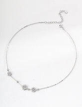 Sterling Silver Floral Charm Necklace displayed on a white surface, minimalist and perfect for layering.