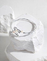 Silver bracelet with pearls on a white stone background