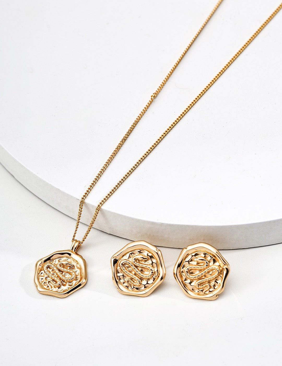Gold necklace with matching hexagonal pendants on a white background