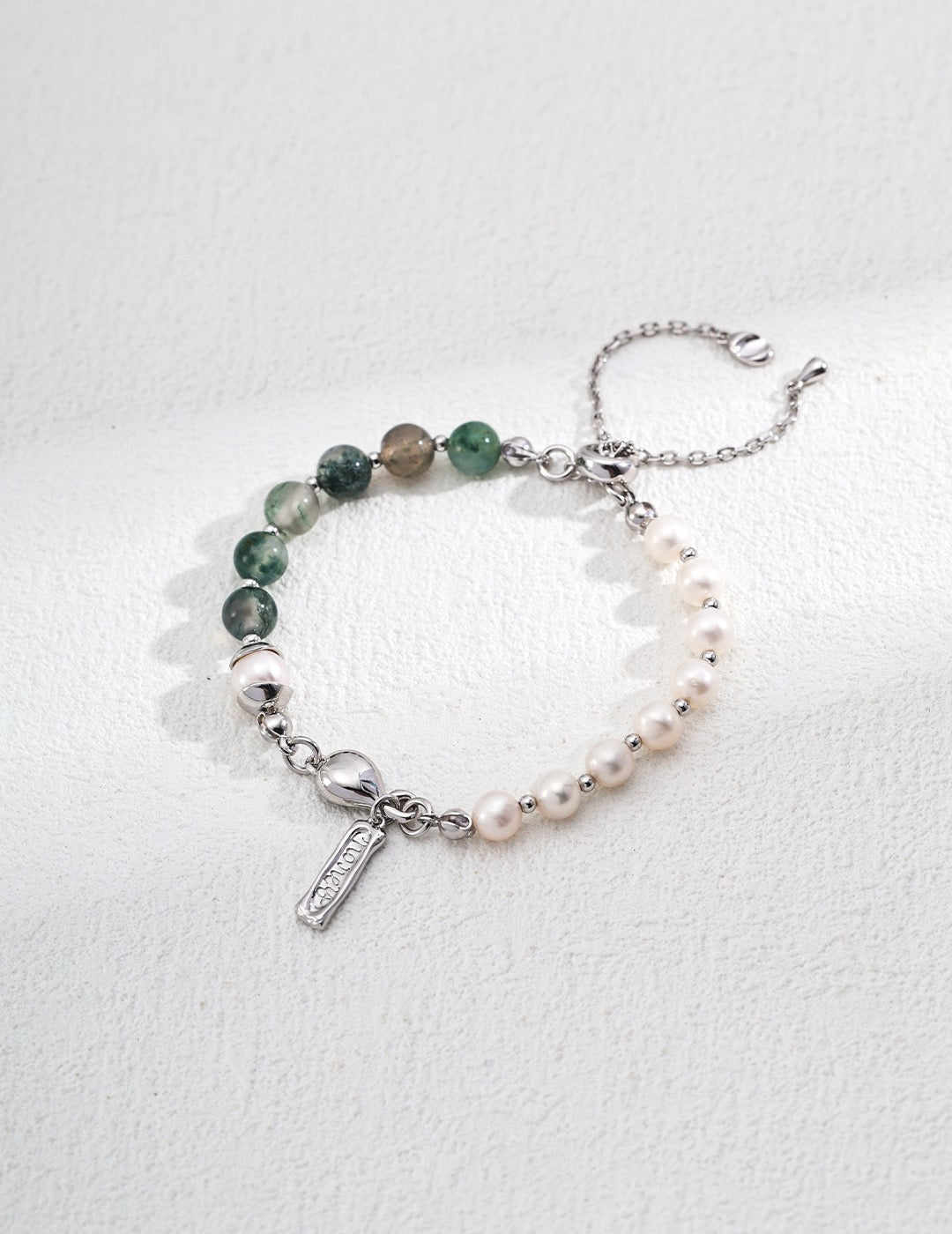 Sterling silver bracelet featuring alternating ocean agate beads and freshwater pearls, accented with a polished heart charm and dainty tag on a delicate chain.
