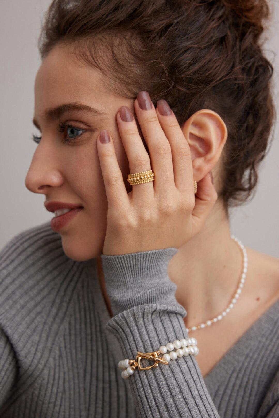 The model wears the Agnes 18K Gold Vermeil Open Ring with a grey sweater - Lia Atelier