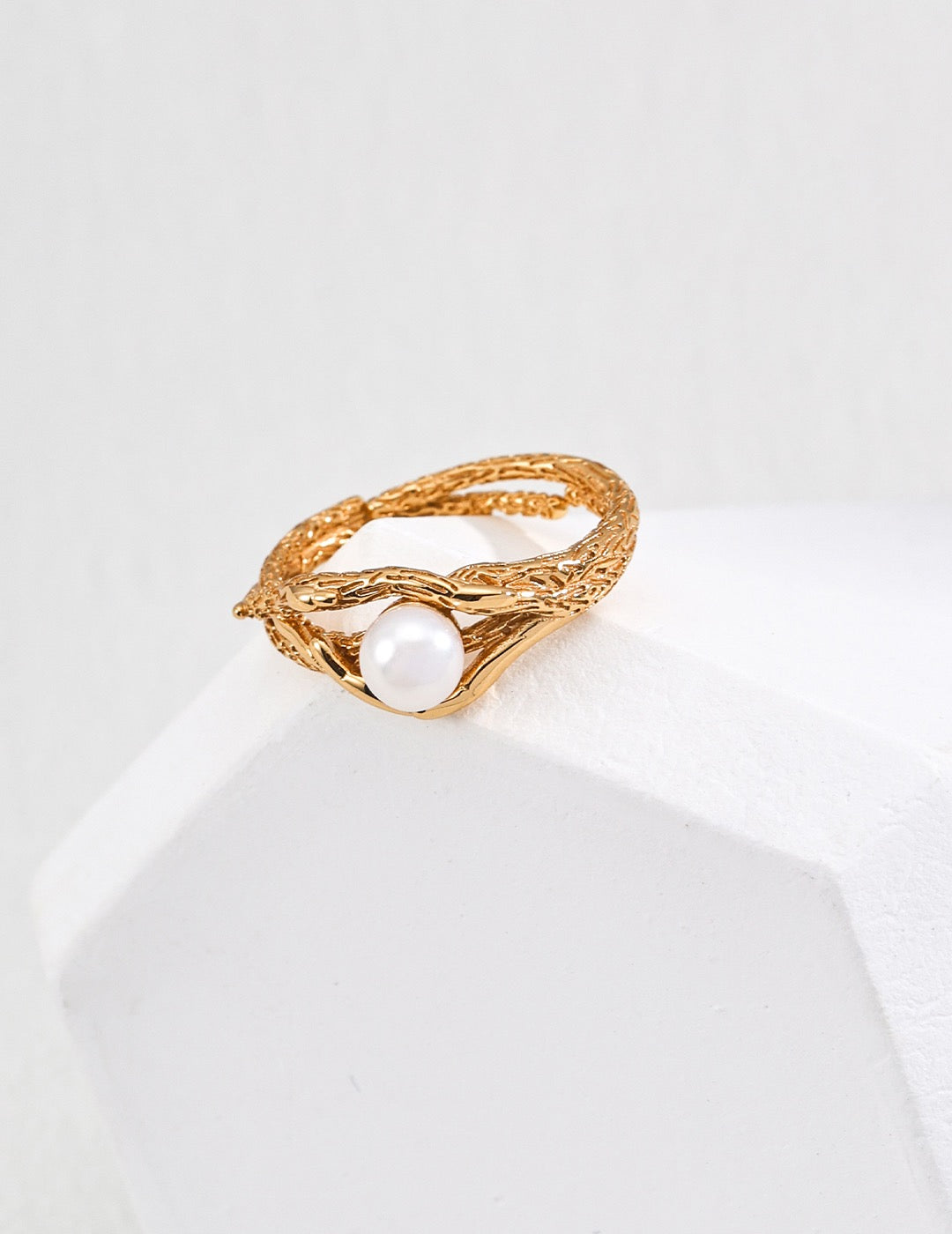 Gold ring with a 5mm pearl on a white background