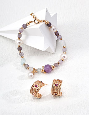 Bracelet and earrings set with purple and gold jewelry on a white background.