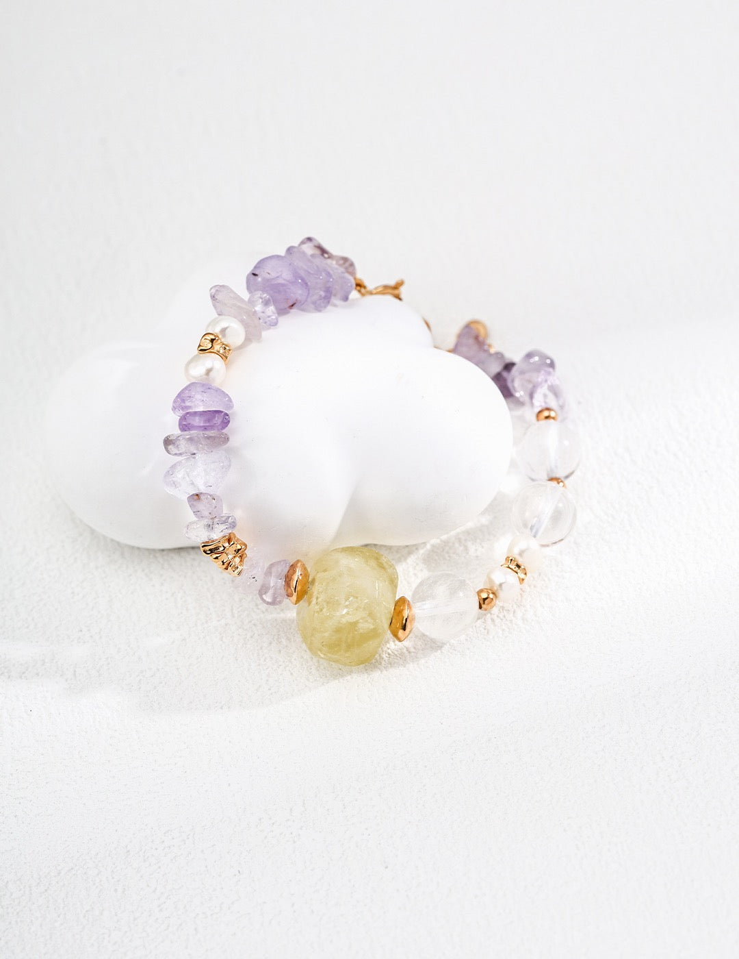 Bracelet with amethyst, citrine, rose quartz, and freshwater pearls on a white background