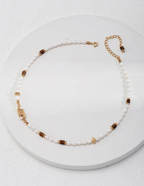 Front view of the tiger eye gemstone necklace display on a white circle surface