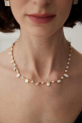A close-up image of a woman's neck wearing a bamboo baroque pearl necklace with gold accents.