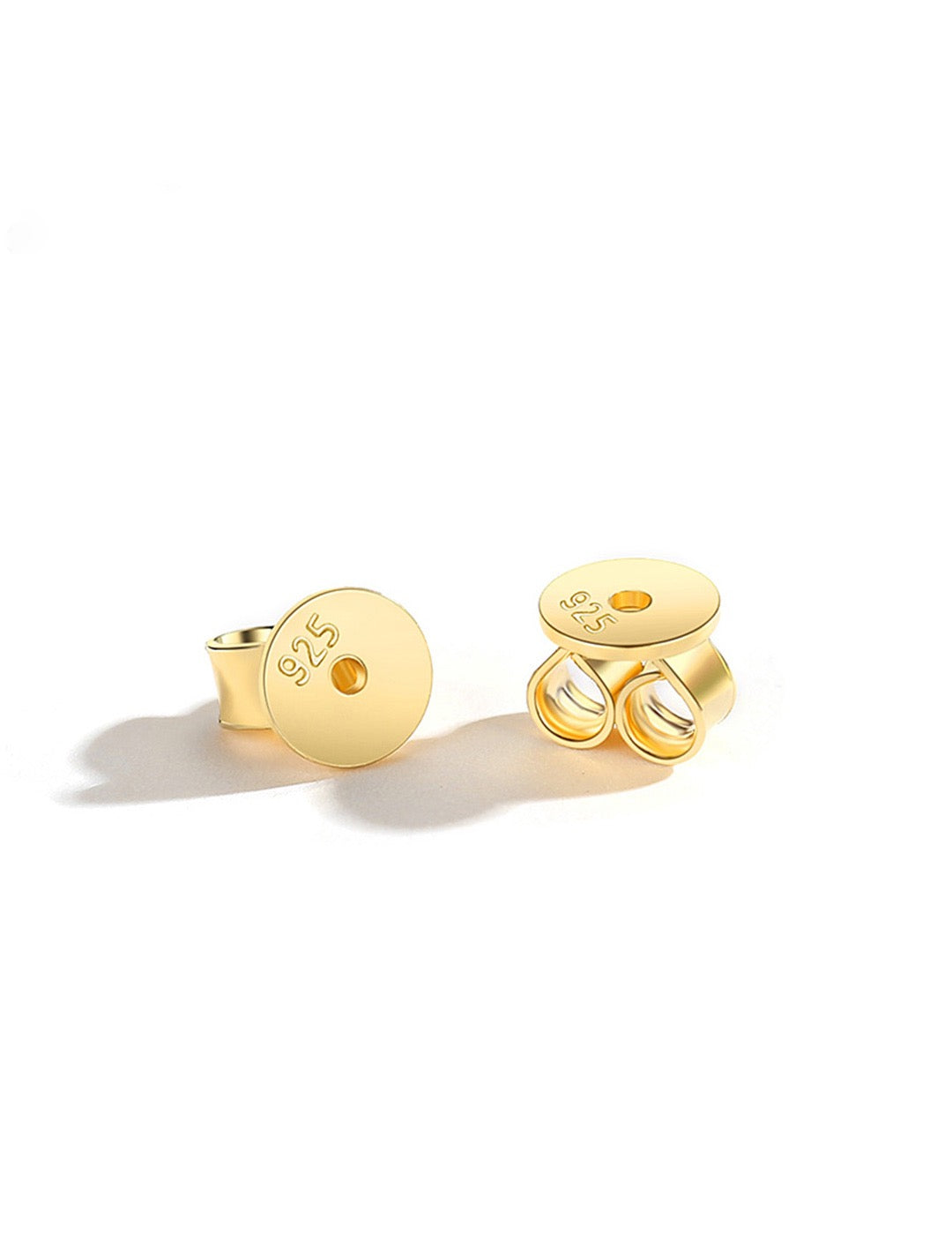 Pair of 18K gold earring backs on a white background
