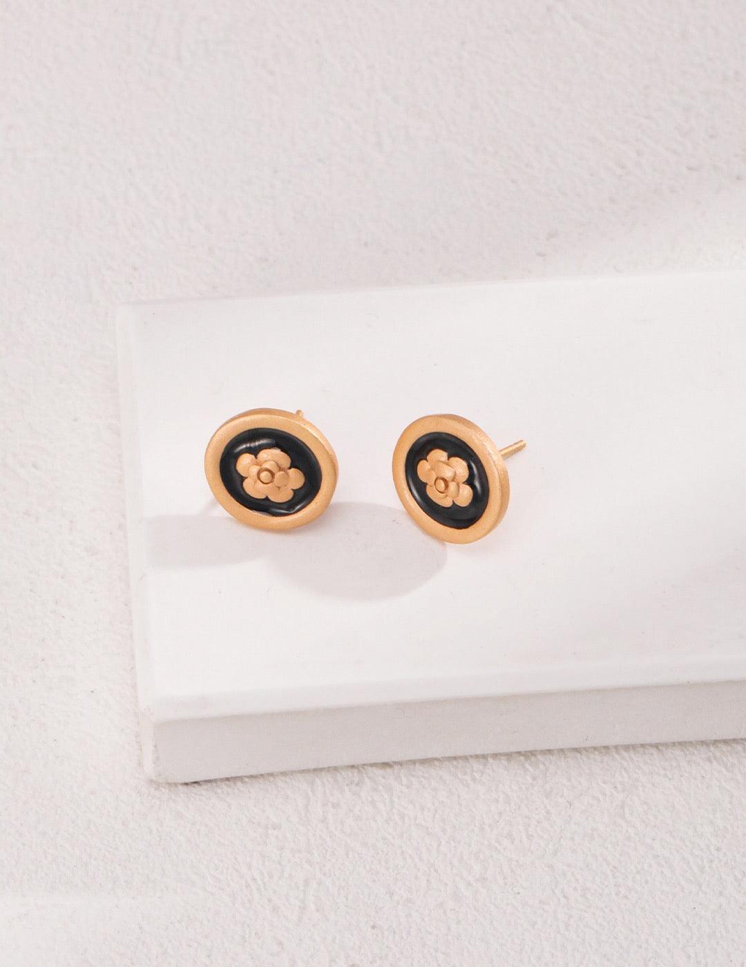 Camellia Stud Earrings displayed on the white rock.
