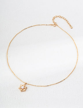 Gold bracelet with a small charm on a white background