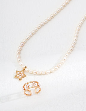 Pearl necklace with gold charms on a white background
