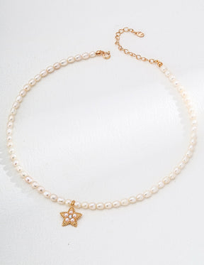 Pearl necklace with a gold star pendant on a white background