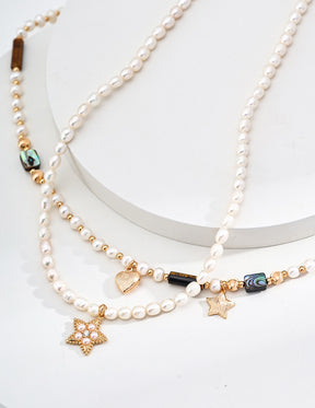 Pearl necklace with star-shaped charms on a white background
