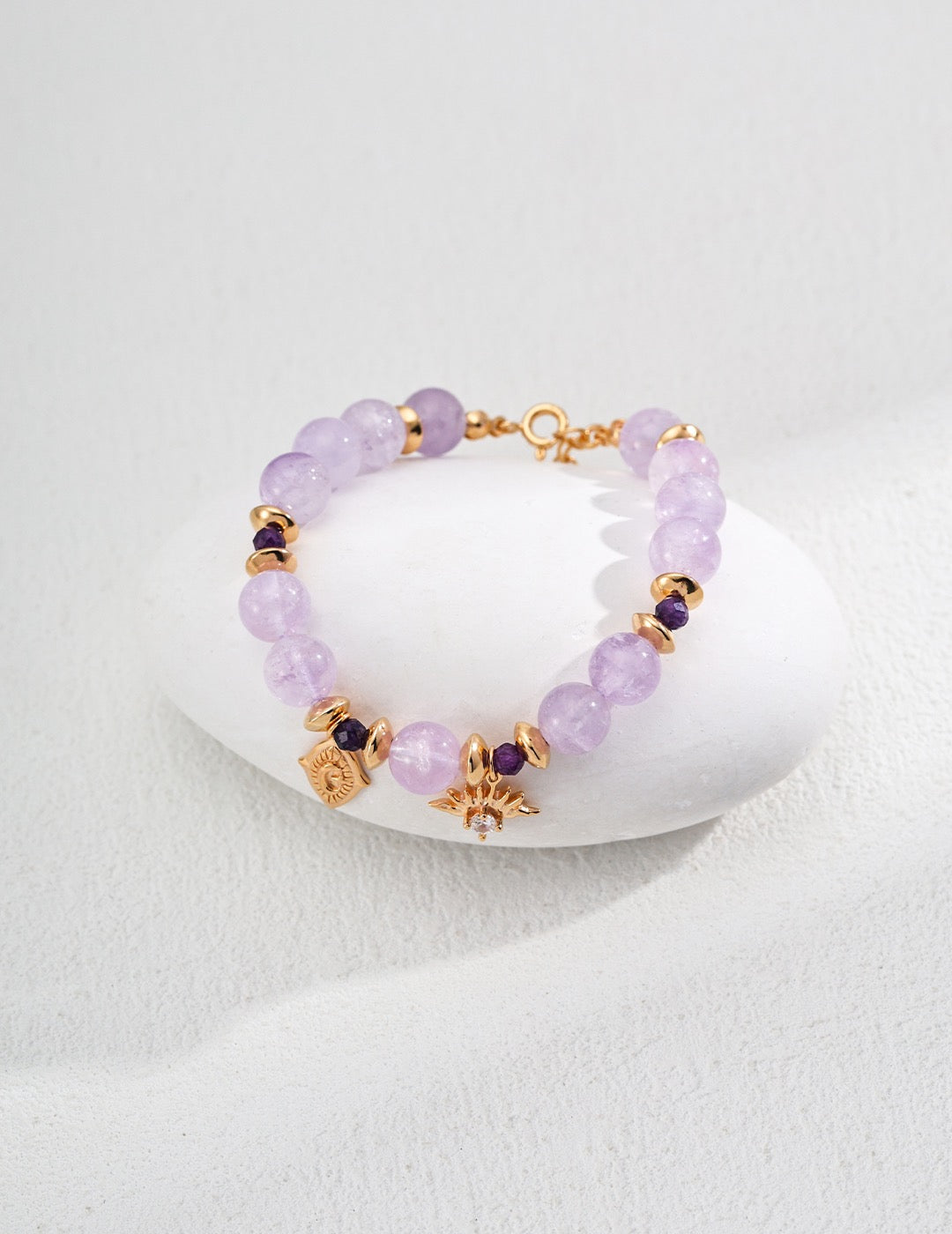 A close-up of Celestial Amethyst Zircon Bracelet in 18K Gold showcases the zircon pendant's details.