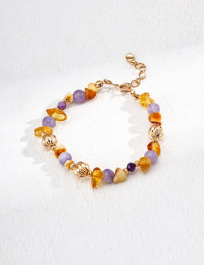 Multicolored gemstone beaded bracelet with gold accents on a white background