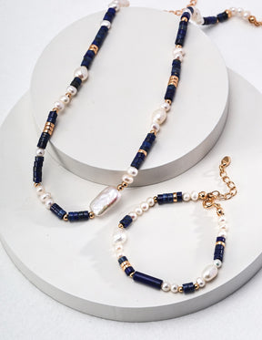 Two beaded necklaces with blue, white, and gold beads on a white surface.