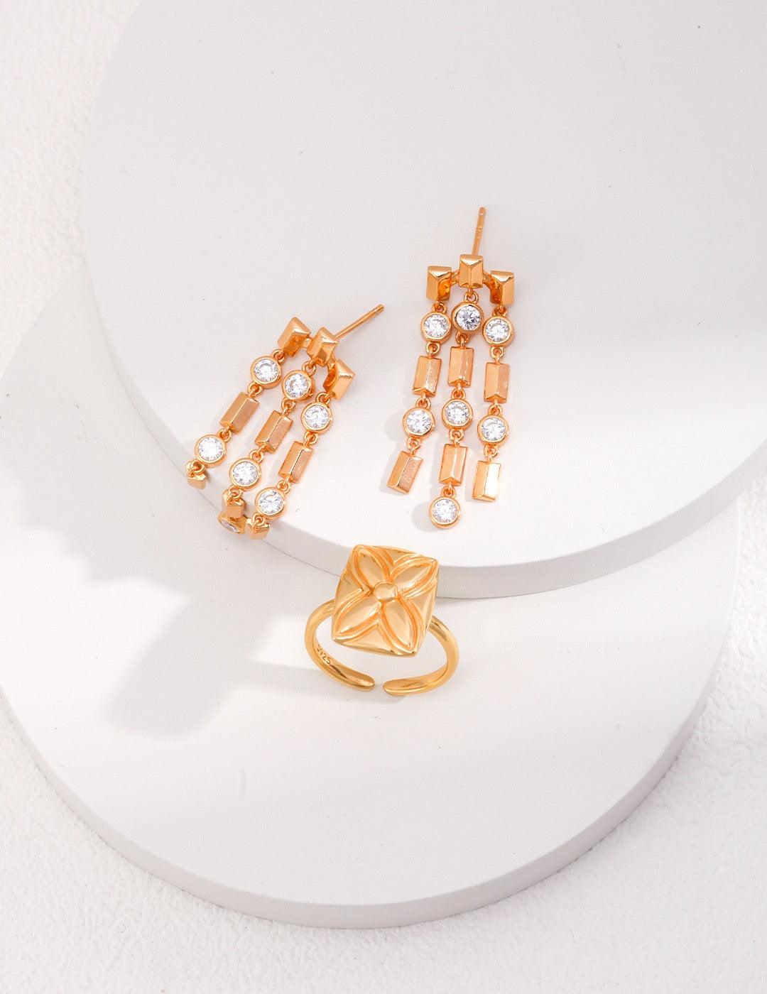 A pair of Clara Tassel Earrings displayed on the white circles.