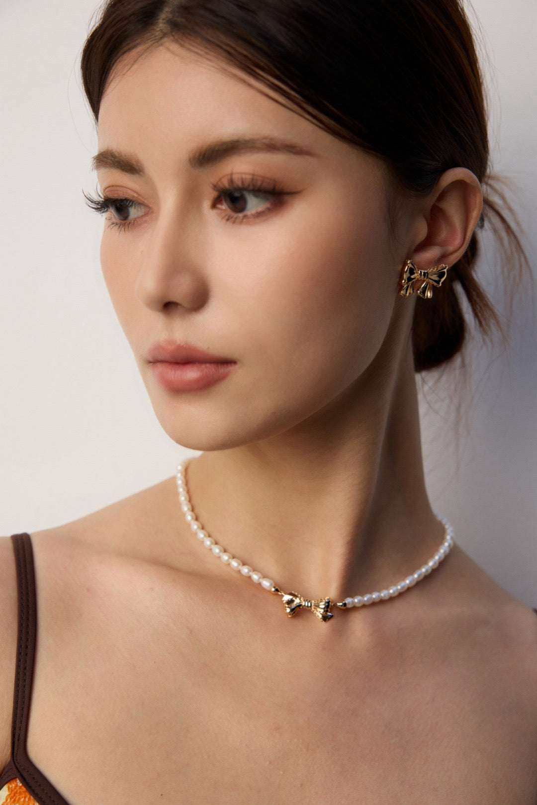 Woman wearing a pearl necklace with a minimal background