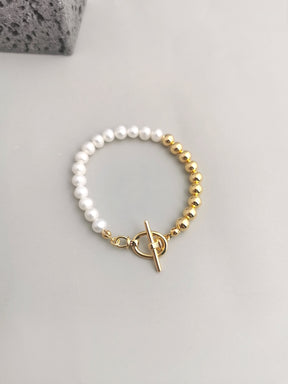 lustrous 6mm freshwater pearls with gleaming 18K gold vermeil beads in perfect symmetry displayed on the grey background.