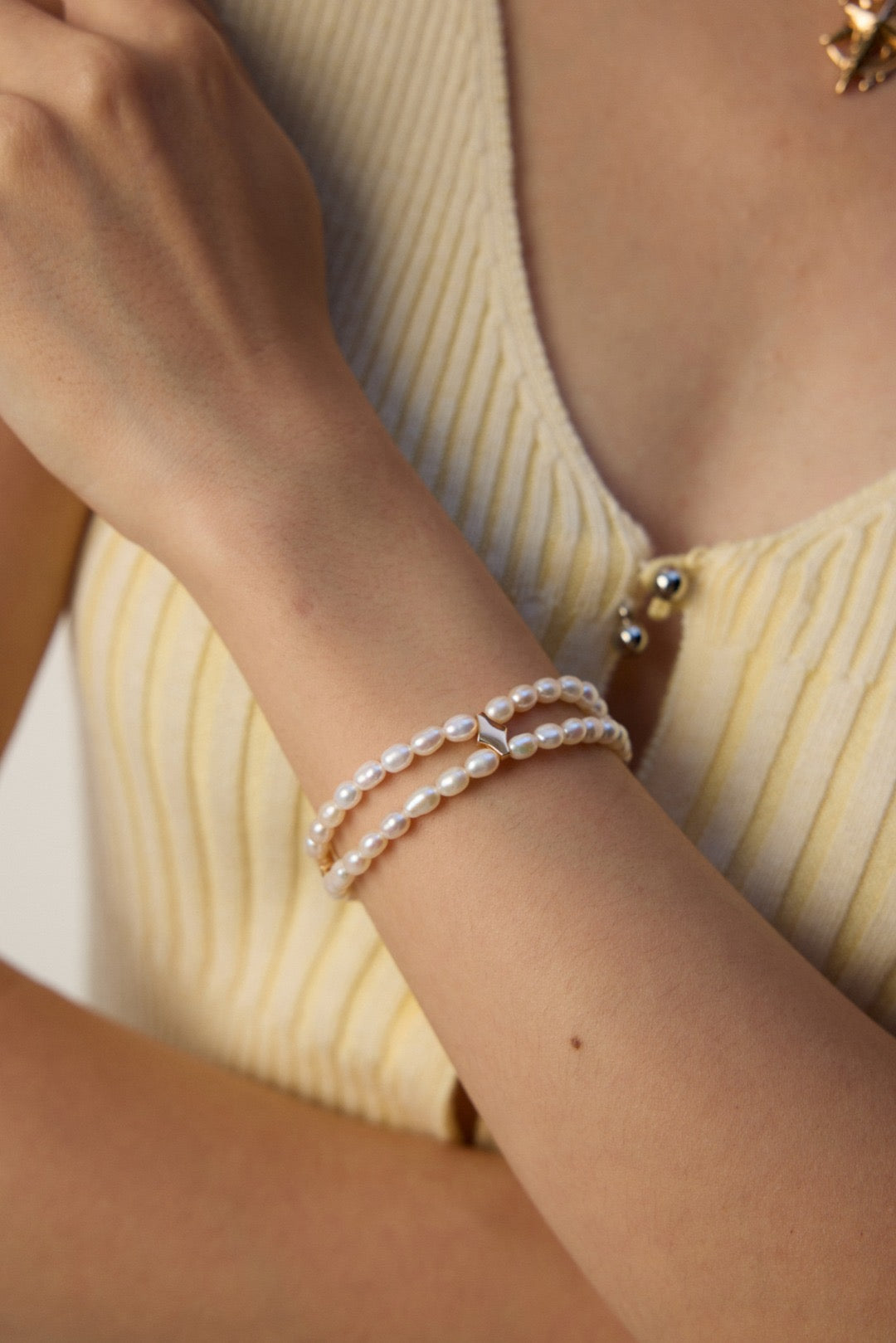 Pearl bracelet on a wrist with a neutral background