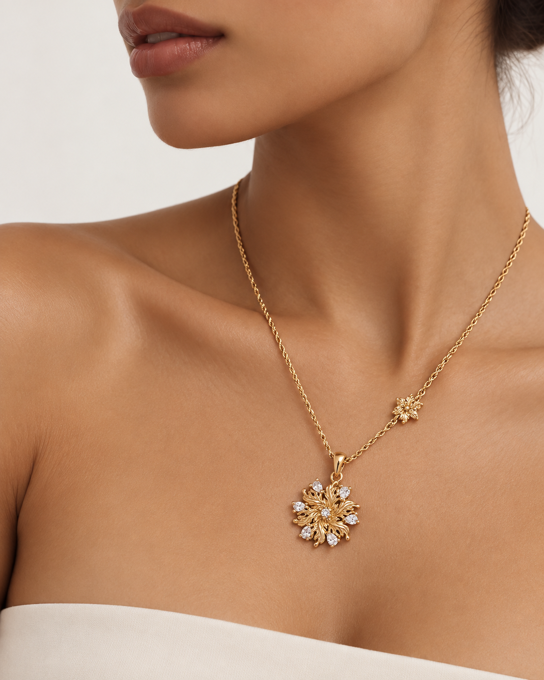 Model wearing the Elowen Radiant Bloom Pendant Necklace with a gold floral pendant and zircon accents.